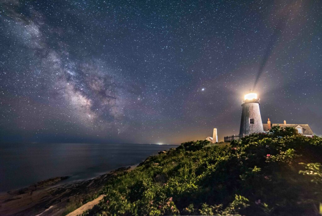 lighthouse below a starry night - Maine Travel Guide